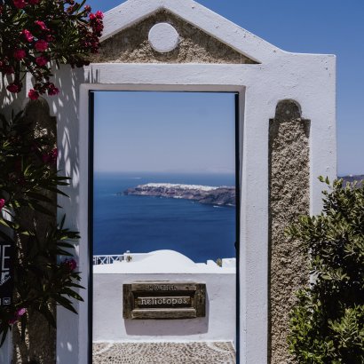 A través de una puerta hacia la orilla de la playa en la isla de Santorini